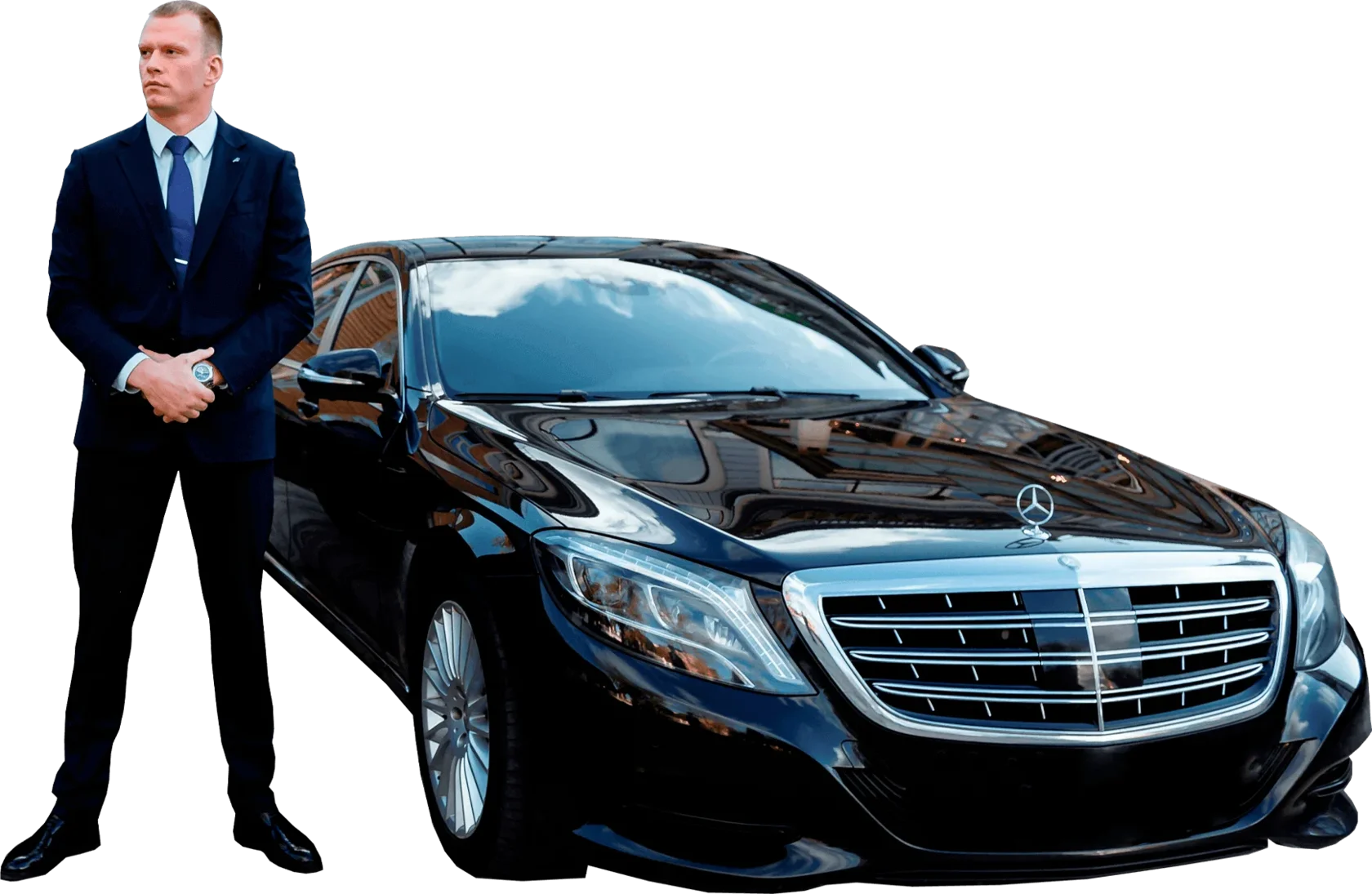 Man in a suit standing beside a sedan